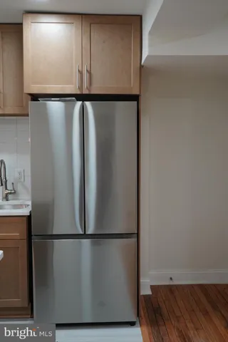 a view of a refrigerator and wooden floor