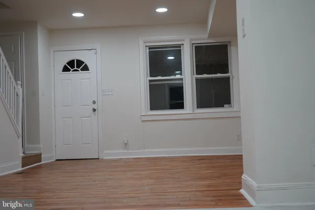 a view of an empty room with wooden floor and cabinet