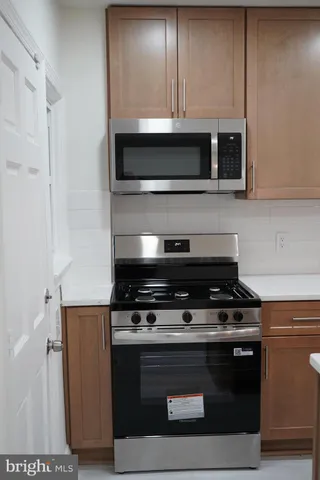 a stove top oven sitting inside of a kitchen