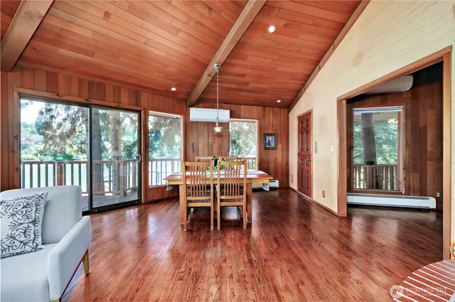 a dining room with wooden floor and furniture