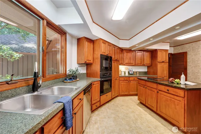 a kitchen with stainless steel appliances granite countertop sink stove and refrigerator