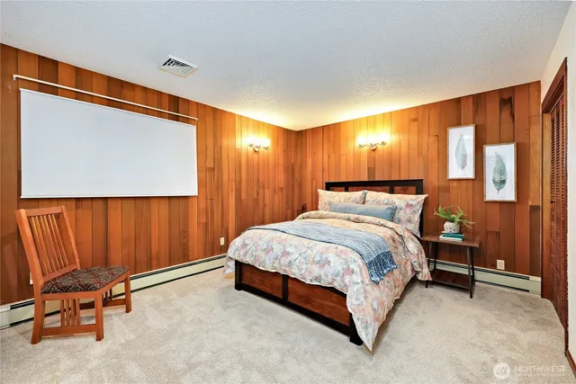 a bed sitting in a room next to a lamp and a large window with wooden floor