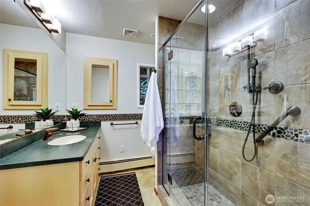 a bathroom with a double vanity sink mirror and shower