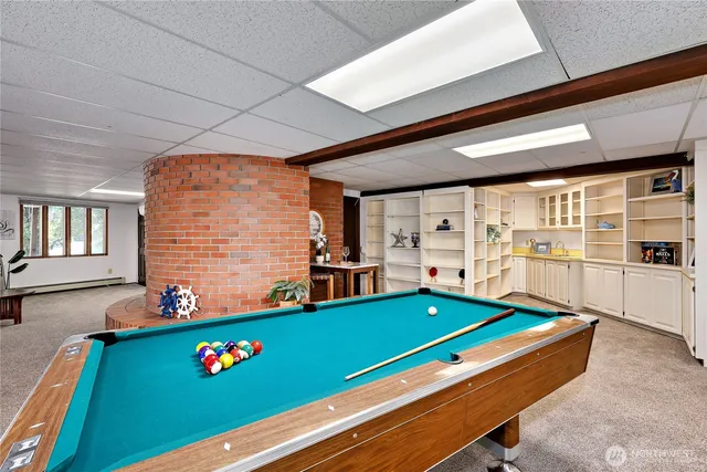 a room with pool table and windows