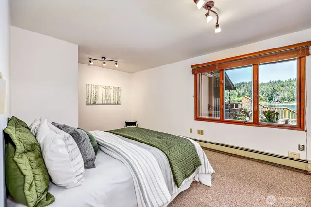 a bedroom with a bed and a large window