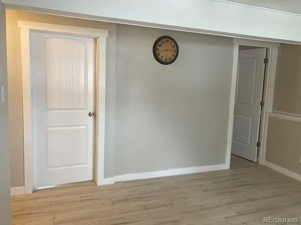 an empty room with a refrigerator and a mirror