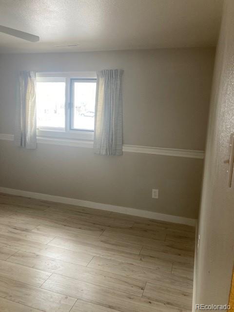 102 Third Street Berthoud, CO 80513 - Photo 22 of 35 a view of an empty room with wooden floor and a window
