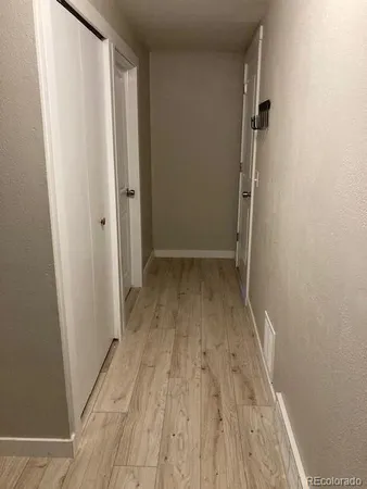 a view of an empty room with wooden floor