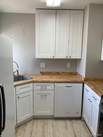 a kitchen with granite countertop cabinets sink and stove