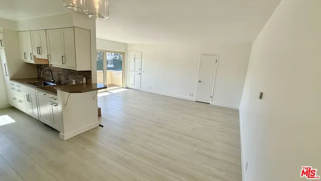 a kitchen with stainless steel appliances a stove and white cabinets