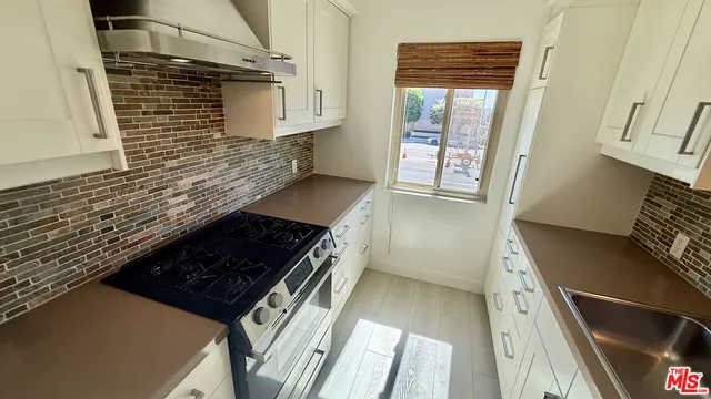 a kitchen with wooden cabinets and a stove top oven