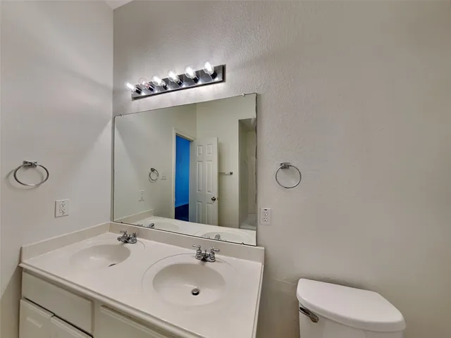 a bathroom with a sink mirror and toilet