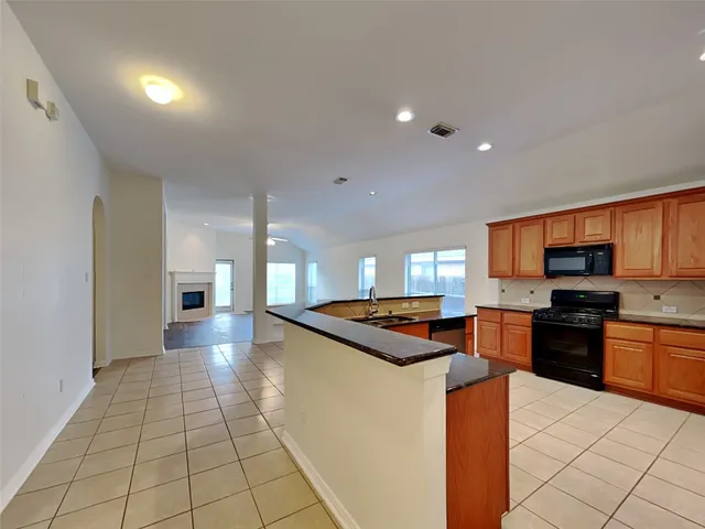 a kitchen with stainless steel appliances granite countertop a sink and a stove
