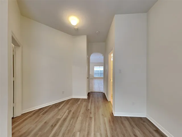 a view of a room with wooden floor a fireplace and windows