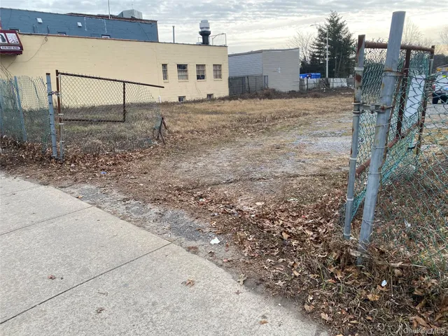 a view of a dry yard with wooden fence