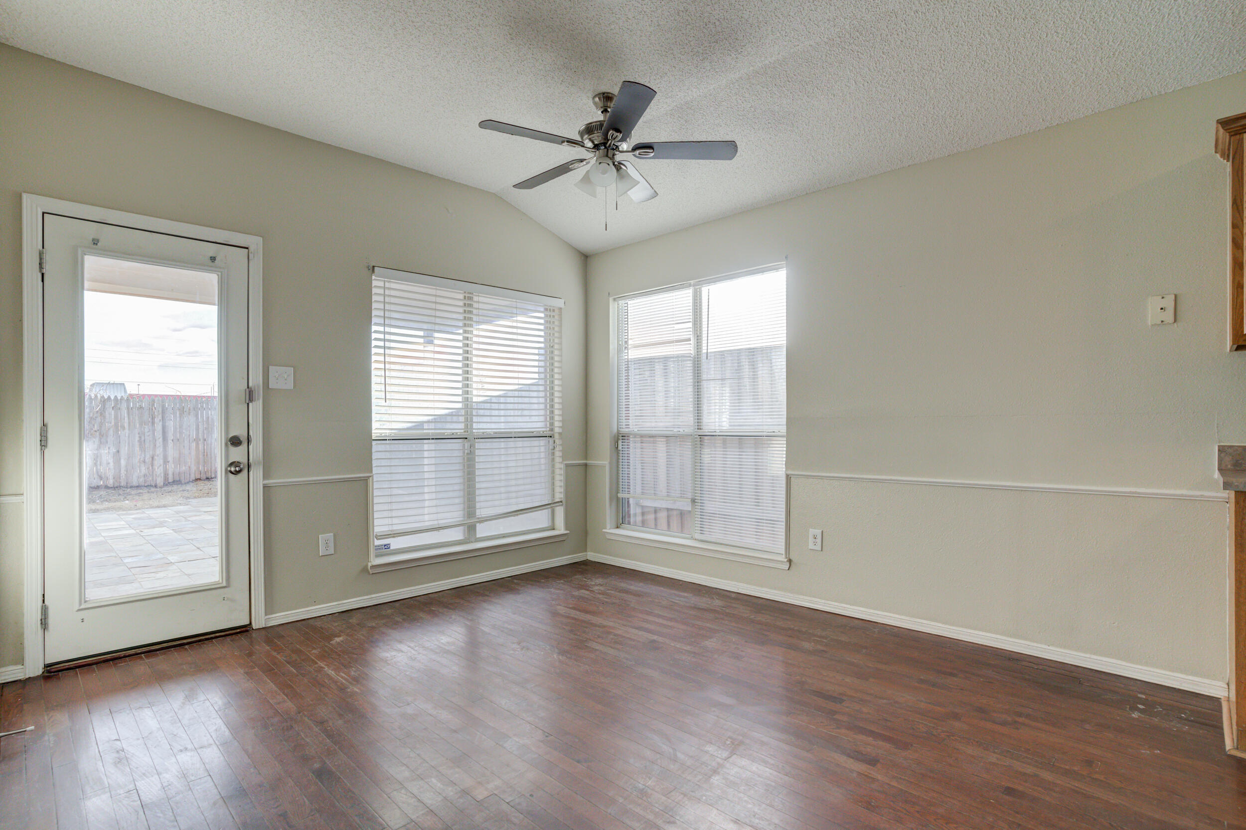 6221 18th Street Lubbock, TX 79416 - Photo 13 of 48 an empty room with wooden floor fan and windows