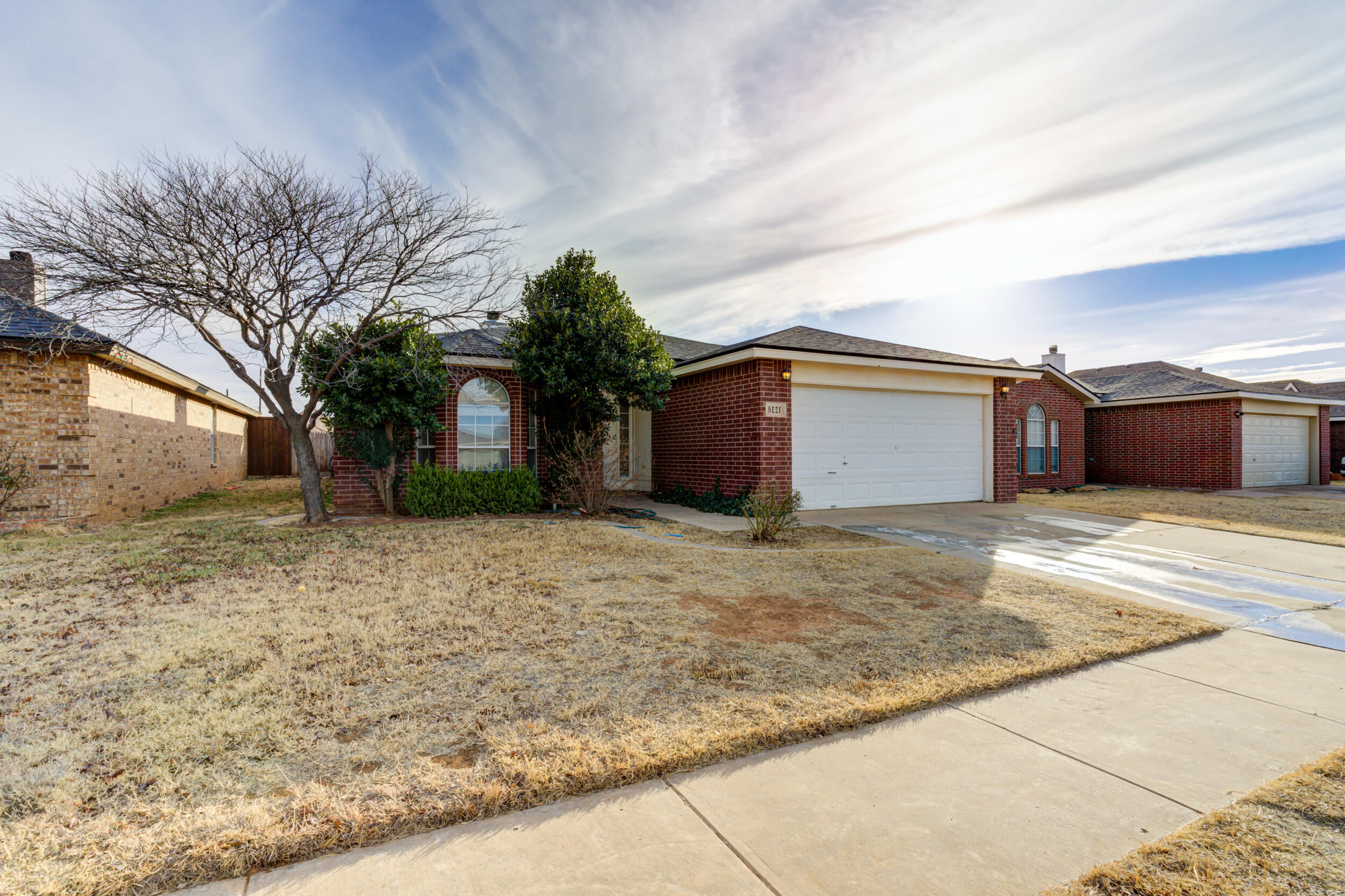 6221 18th Street Lubbock, TX 79416 - Photo 2 of 48 a front view of a house with a yard and garage