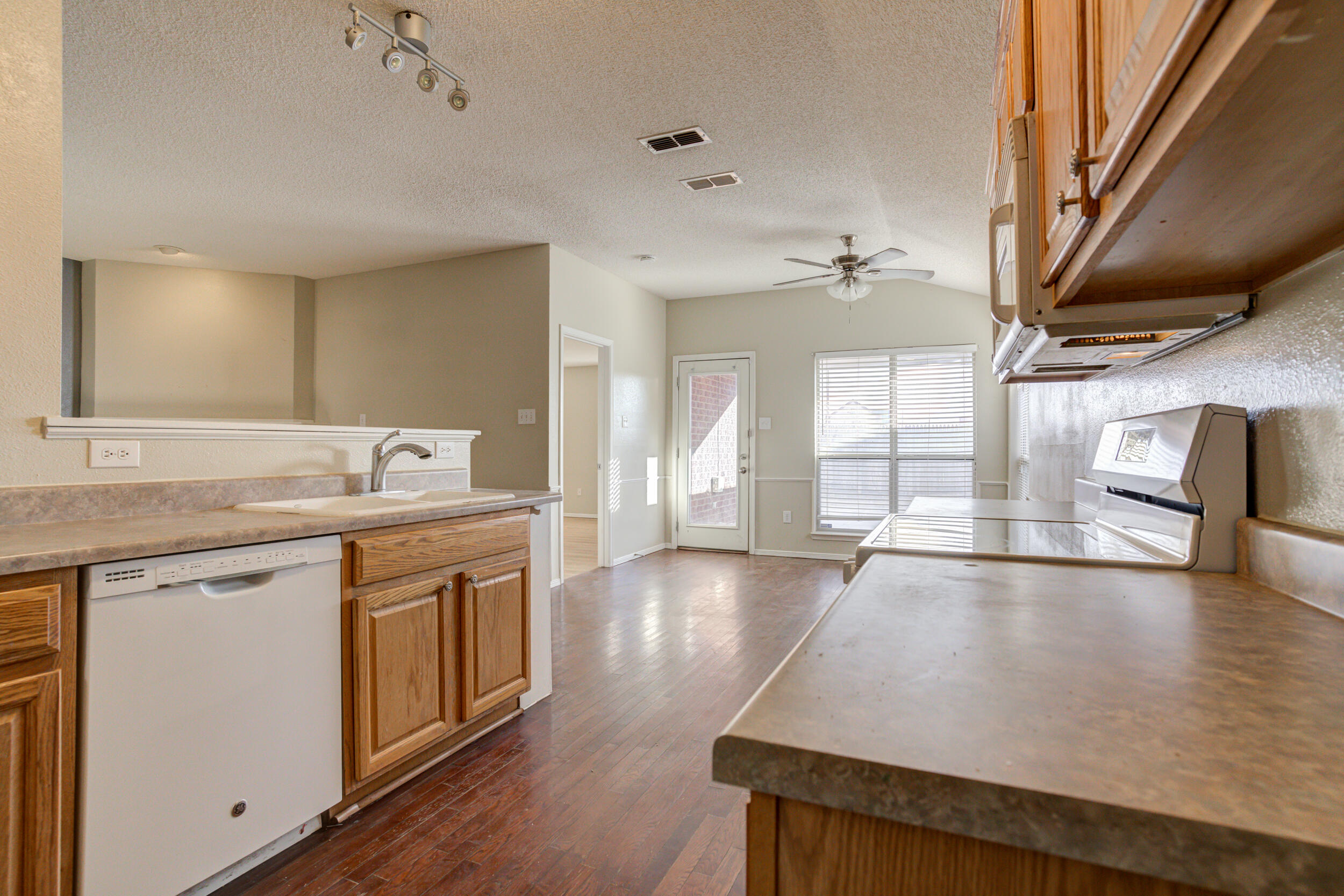 6221 18th Street Lubbock, TX 79416 - Photo 23 of 48 a view of a kitchen with stainless steel appliances granite countertop a sink wooden floor and a large window