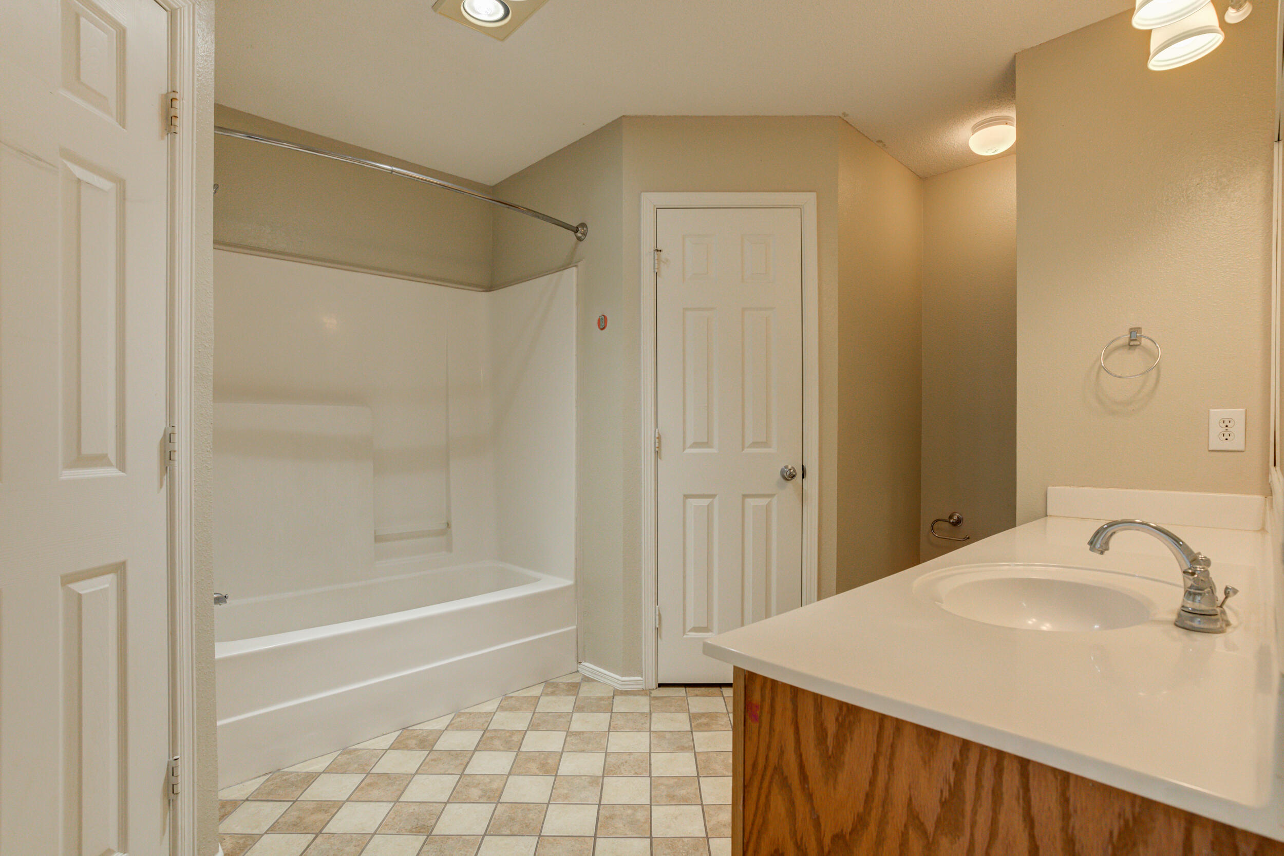 6221 18th Street Lubbock, TX 79416 - Photo 35 of 48 a bathroom with a granite countertop sink a mirror and a bathtub