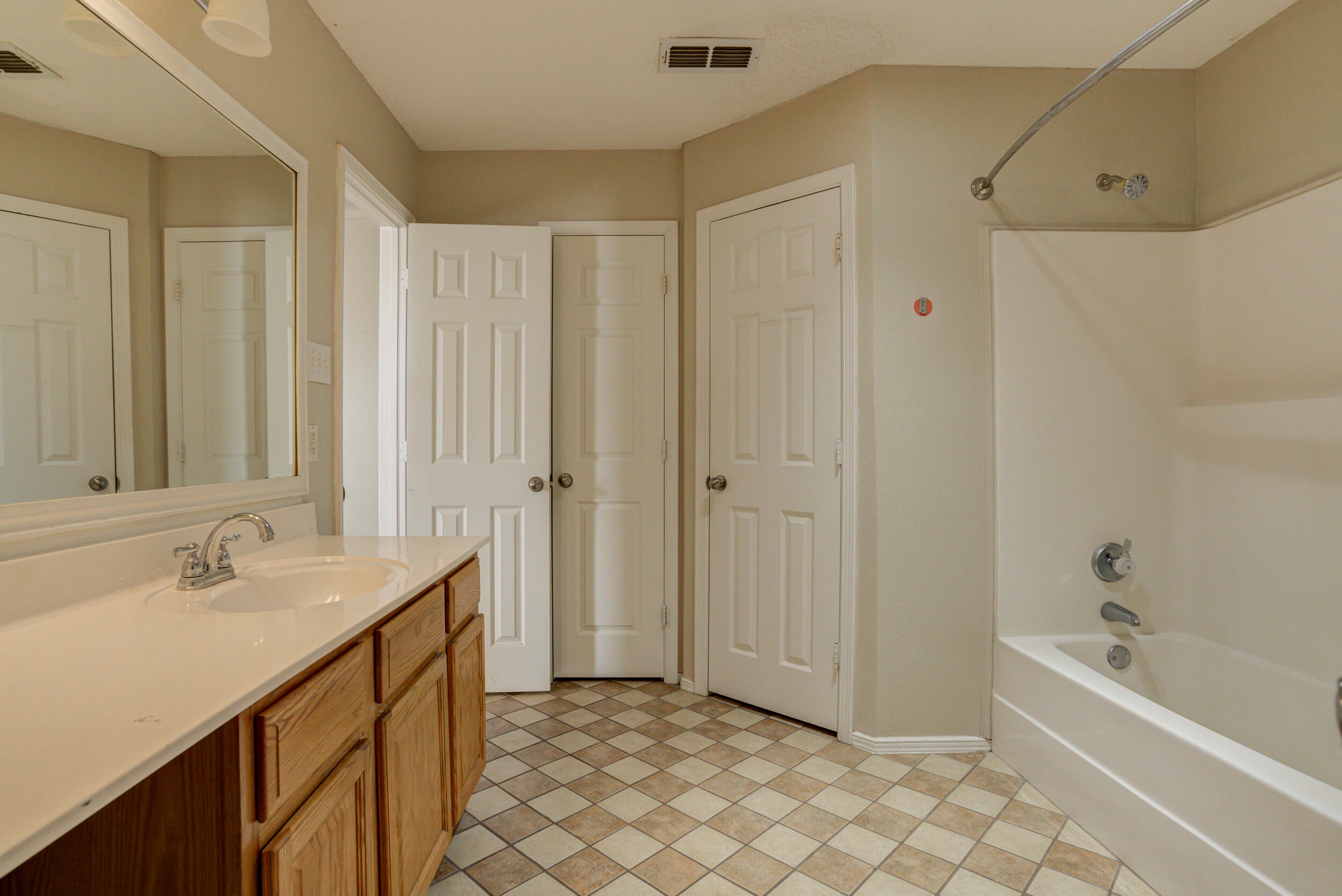 6221 18th Street Lubbock, TX 79416 - Photo 37 of 48 a bathroom with a sink a mirror and a bathtub