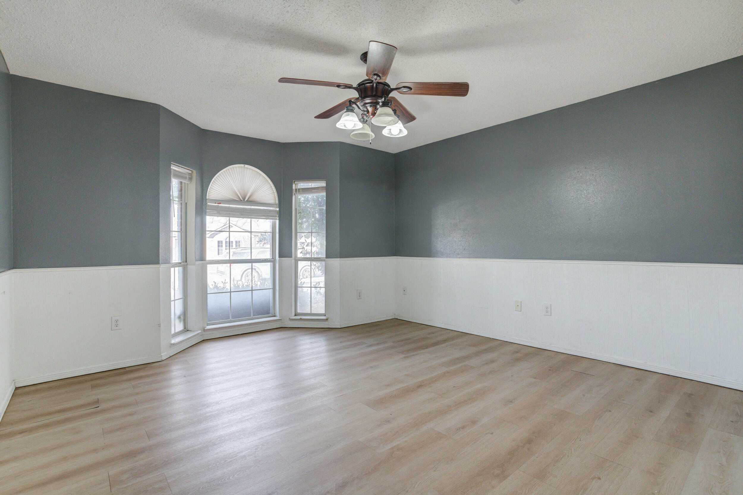 6221 18th Street Lubbock, TX 79416 - Photo 39 of 48 an empty room with wooden floor chandelier fan and windows