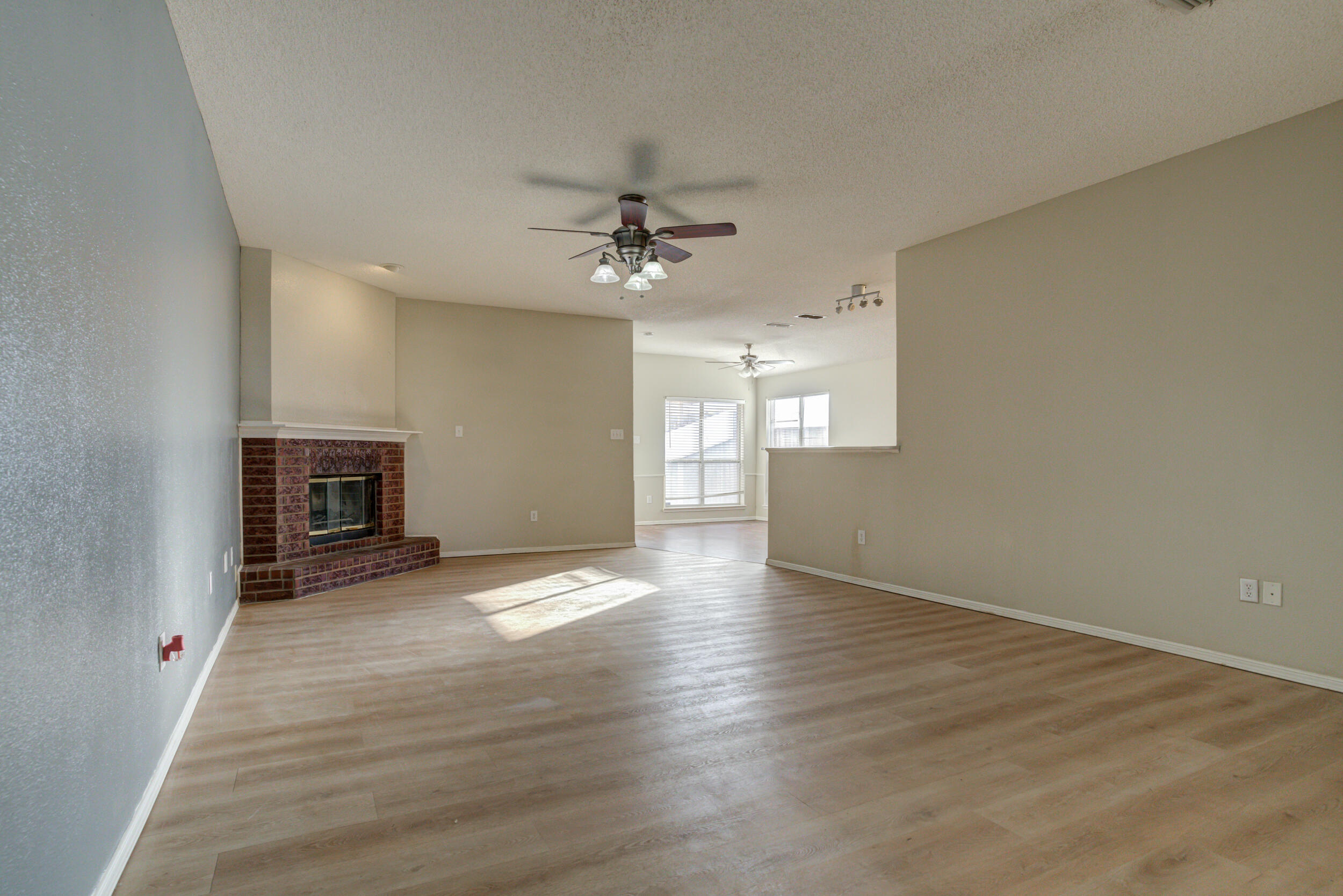 6221 18th Street Lubbock, TX 79416 - Photo 5 of 48 wooden floor in an empty room with a fireplace