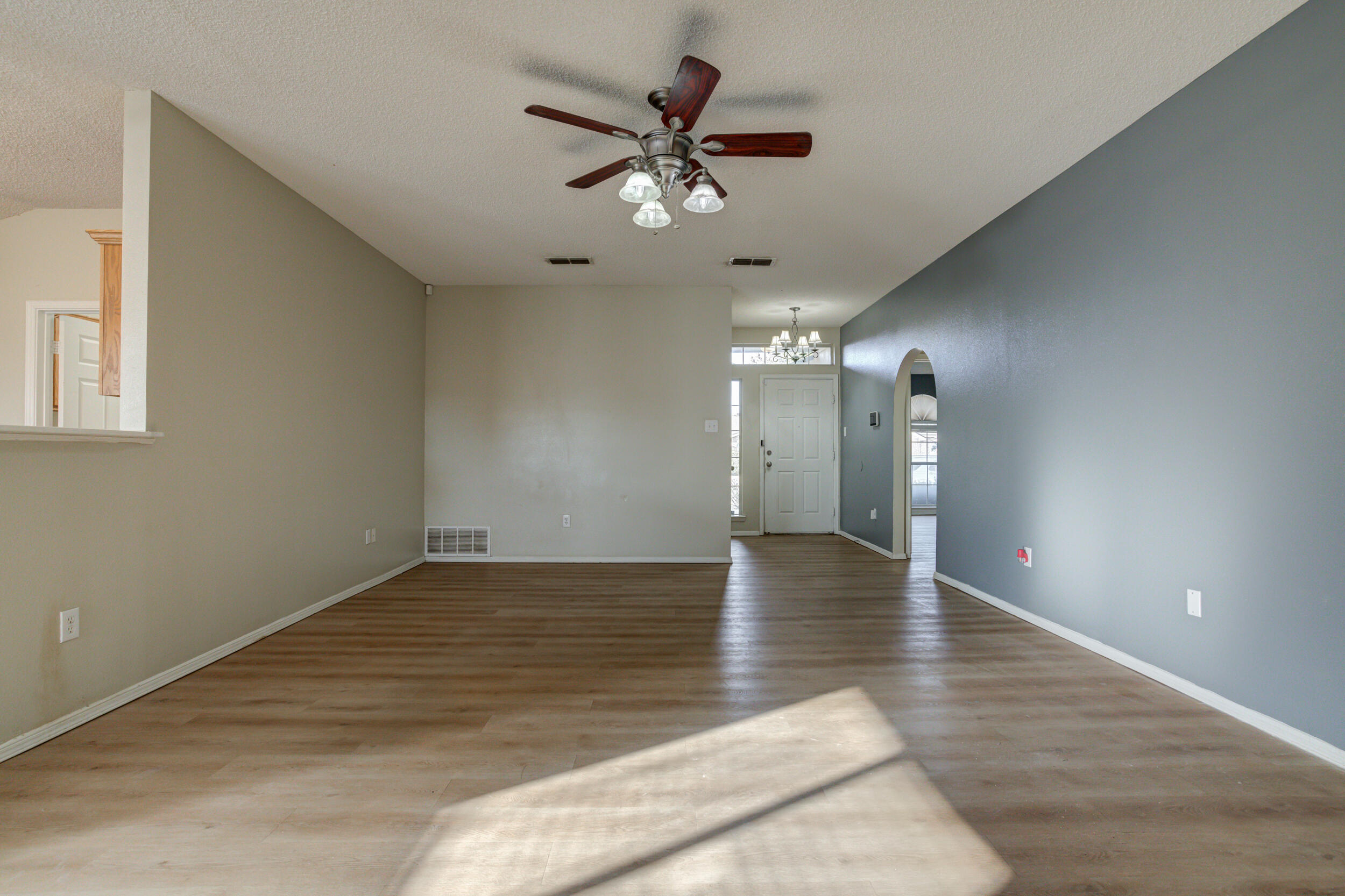 6221 18th Street Lubbock, TX 79416 - Photo 8 of 48 a view of an empty room with a ceiling fan and wooden floor