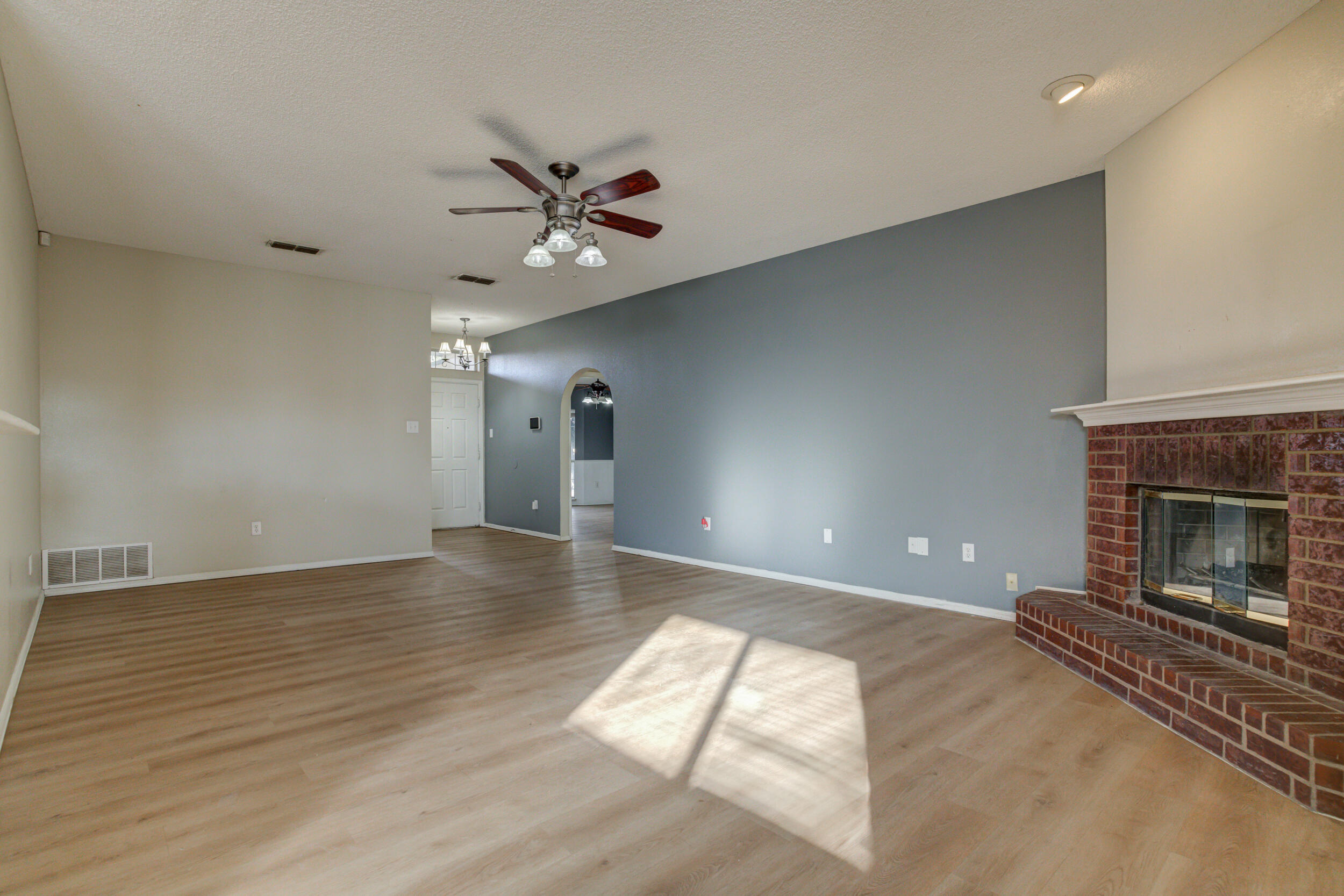 6221 18th Street Lubbock, TX 79416 - Photo 9 of 48 a view of a livingroom with a fireplace a ceiling fan and wooden floor