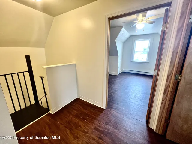 a view of a hallway with wooden floor