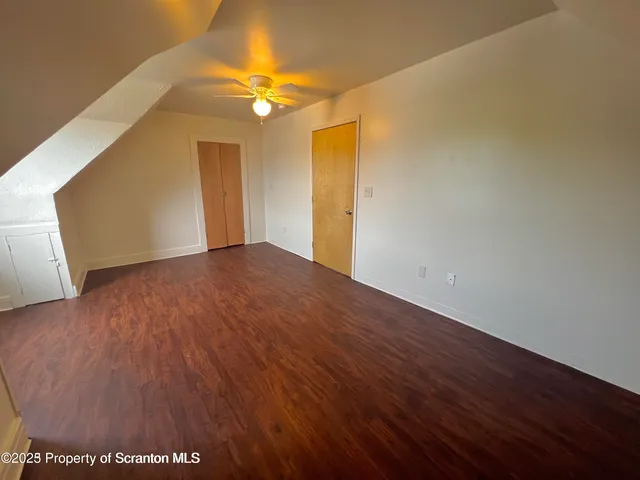 a view of an empty room with wooden floor