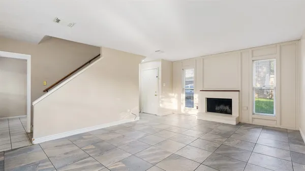 a view of an empty room with a fireplace and a window