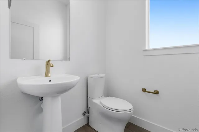 a kitchen with stainless steel appliances granite countertop a sink a stove and white cabinets with wooden floor