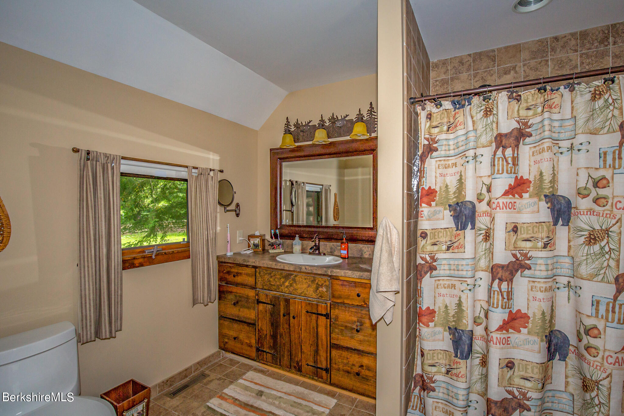 43 Becket Road Otis, MA 01029 - Photo 22 of 41 a bathroom with a granite countertop sink a toilet and shower curtain