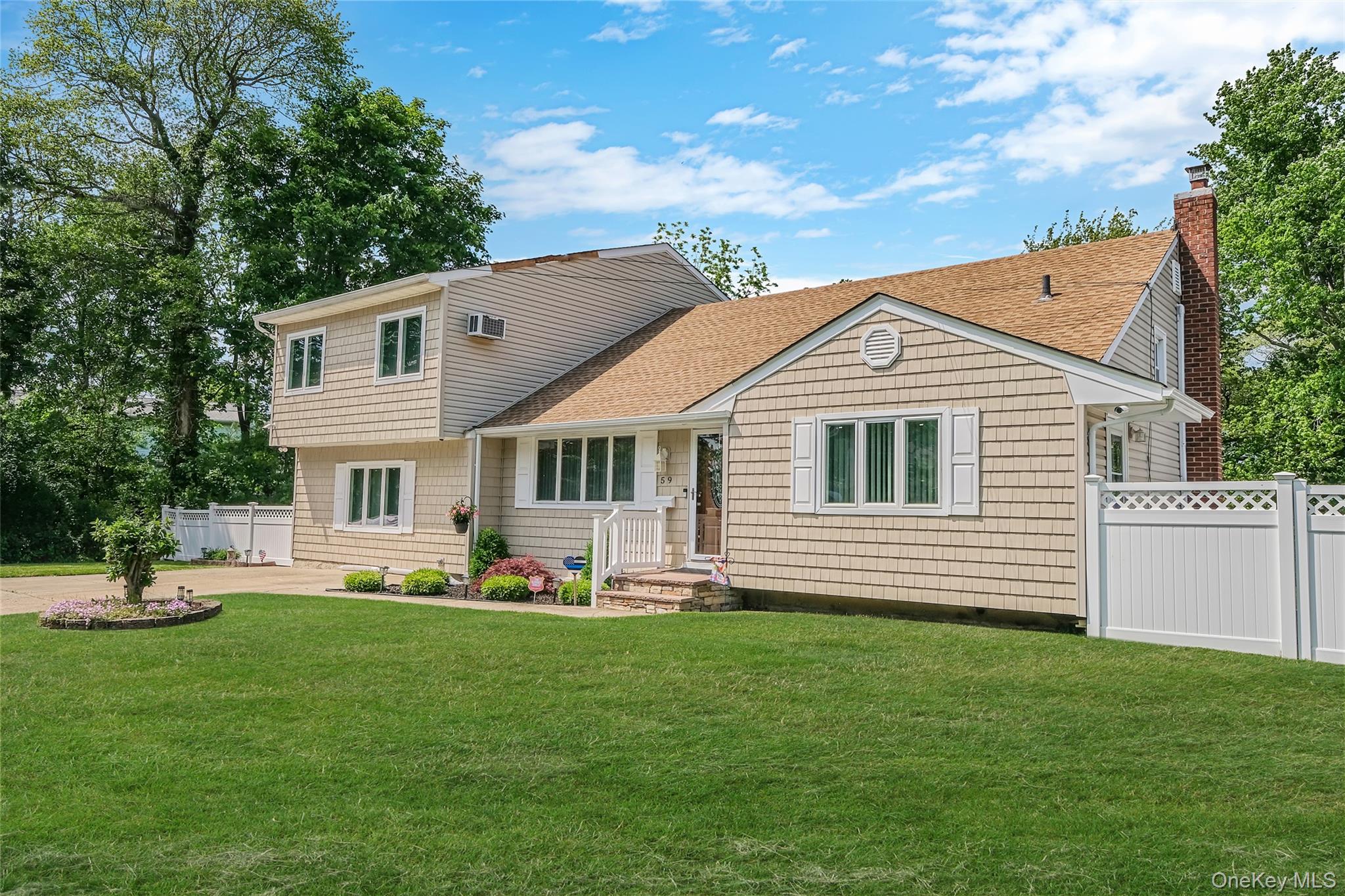 59 Maybrook Road North Babylon, NY 11703 - Photo 3 of 43 a front view of a house with a yard and trees