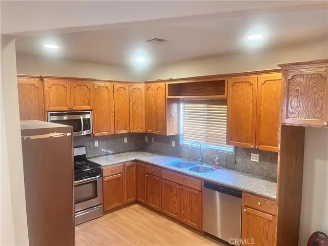 a kitchen with granite countertop a stove top oven microwave and cabinets