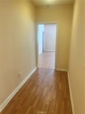 an empty room with wooden floor and window