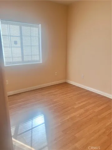 an empty room with wooden floor and entrance