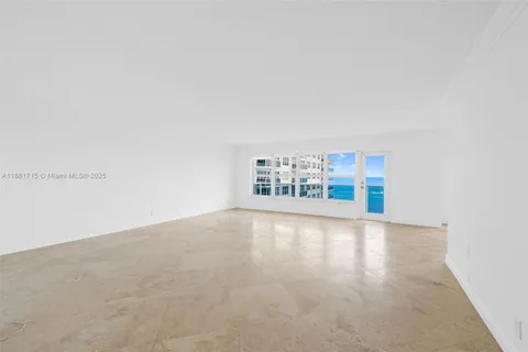 a view of an empty room with kitchen