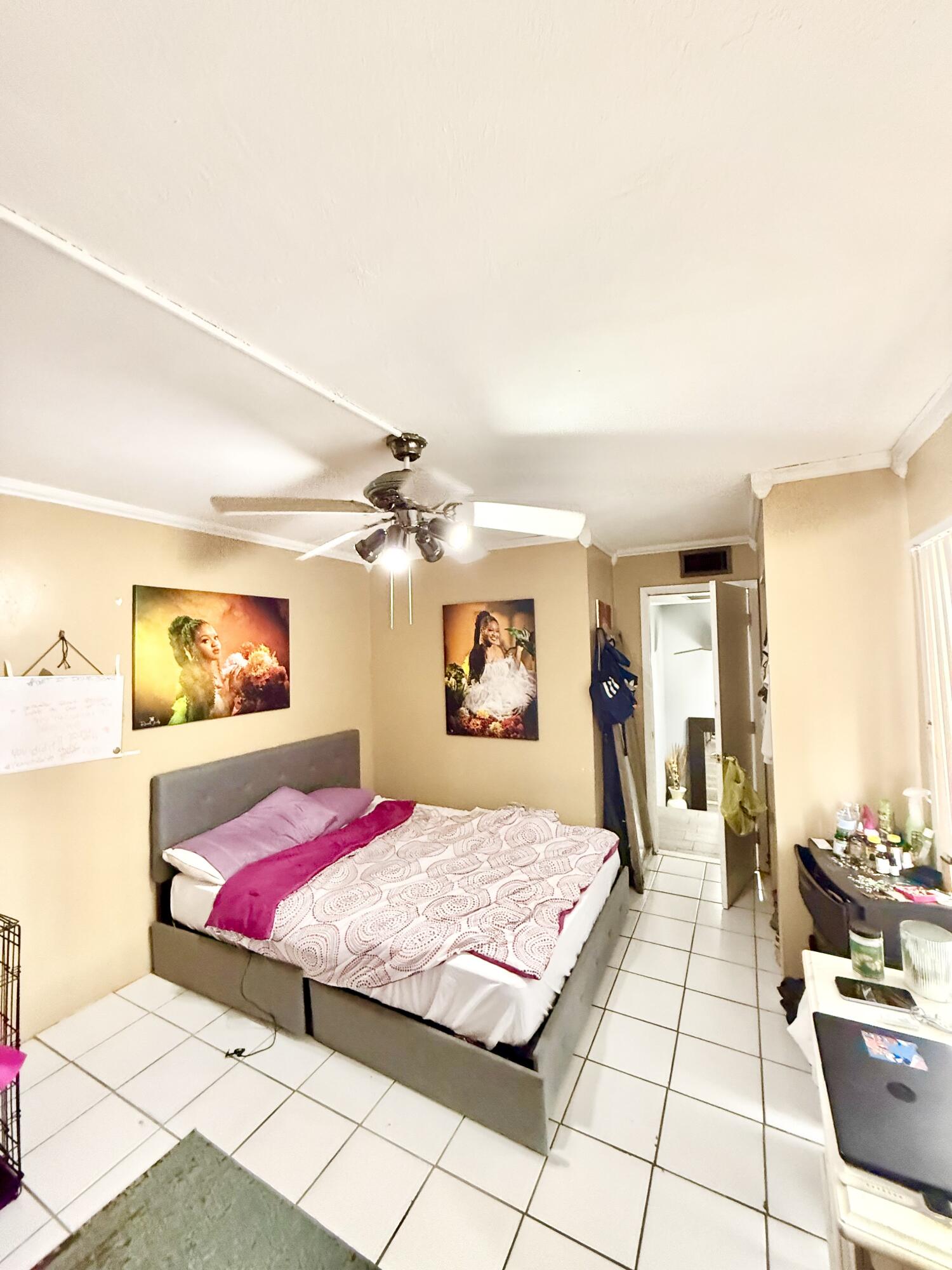 711 Springdale Circle Palm Springs, FL 33461 - Photo 6 of 11 a bedroom with a large bed and a chandelier