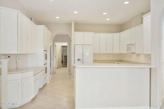an empty room with windows and fireplace