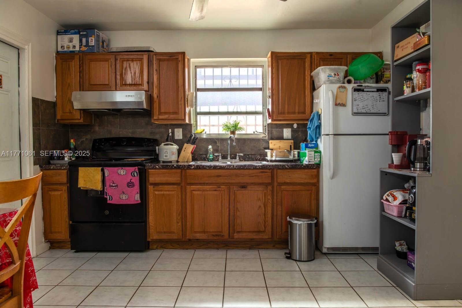 791 Northwest 22nd Place Miami, FL 33125 - Photo 19 of 33 a kitchen with stainless steel appliances granite countertop a refrigerator and a stove