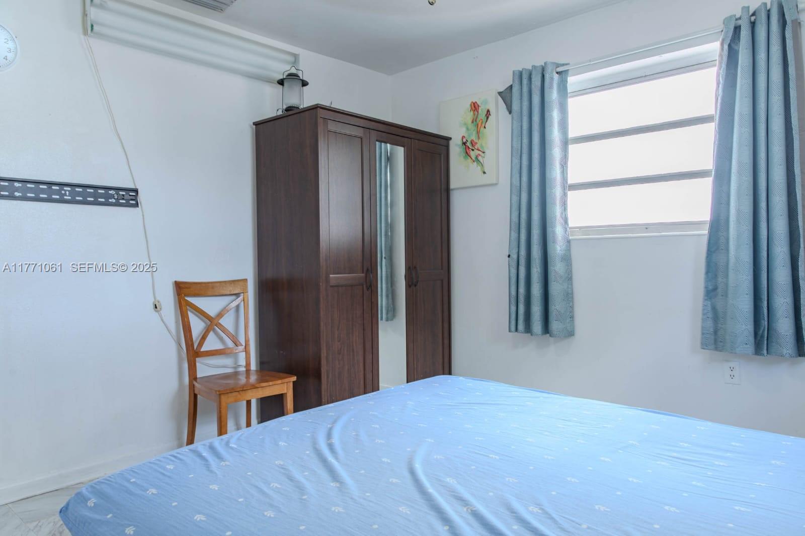 791 Northwest 22nd Place Miami, FL 33125 - Photo 28 of 33 a bedroom with a bed and a window