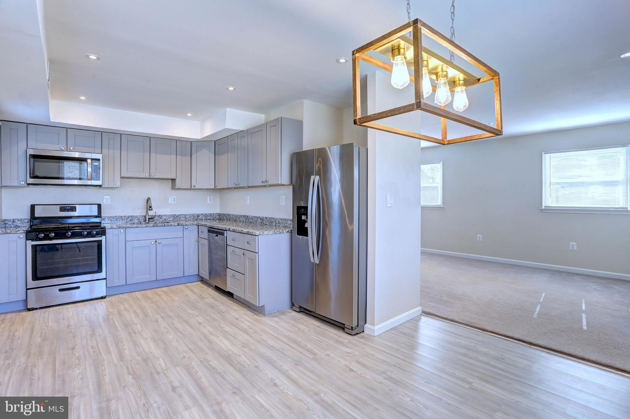 1222 Locust Avenue Halethorpe, MD 21227 - Photo 9 of 34 a kitchen with stainless steel appliances a stove a refrigerator and a microwave