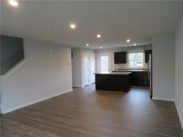 a large kitchen with stainless steel appliances granite countertop a sink counter space and wooden floor