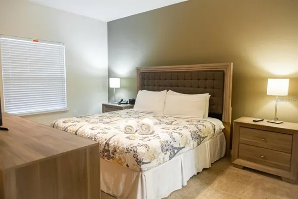 a bedroom with a bed and a flat screen tv