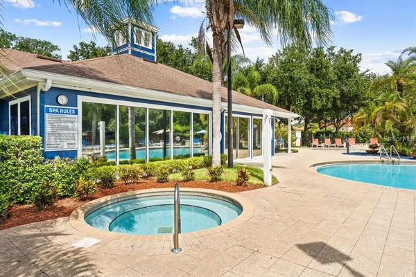 a view of a swimming pool with a lawn chairs under an umbrella