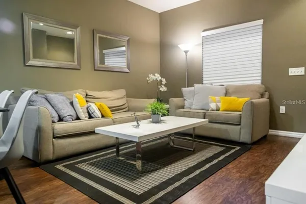 a living room with furniture and wooden floor