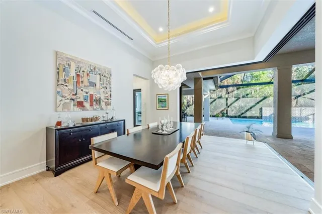 a view of a dining room with furniture a chandelier and wooden floor