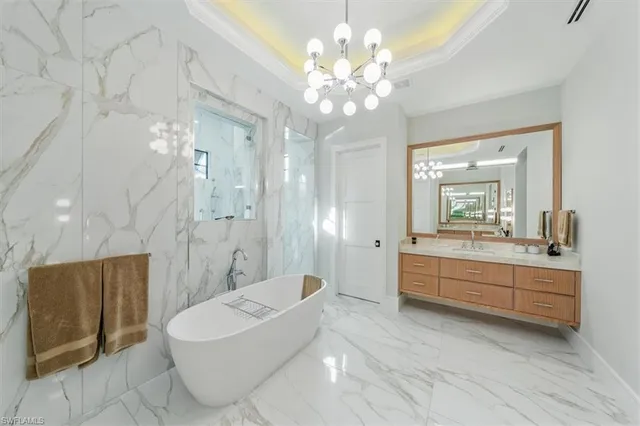 a bathroom with a double vanity sink a large mirror and a bathtub