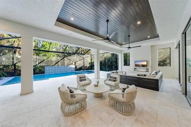 a living room with patio furniture and a floor to ceiling window